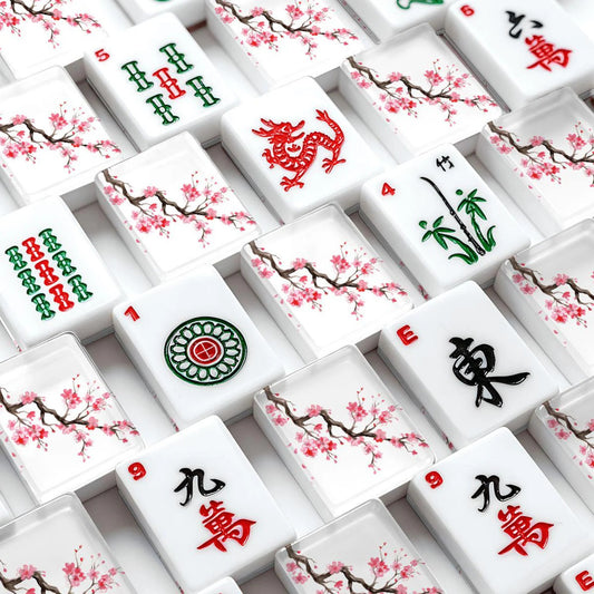 Close-up of a set of white Mahjong tiles with floral cherry blossom designs and traditional Chinese symbols, arranged in a grid pattern.