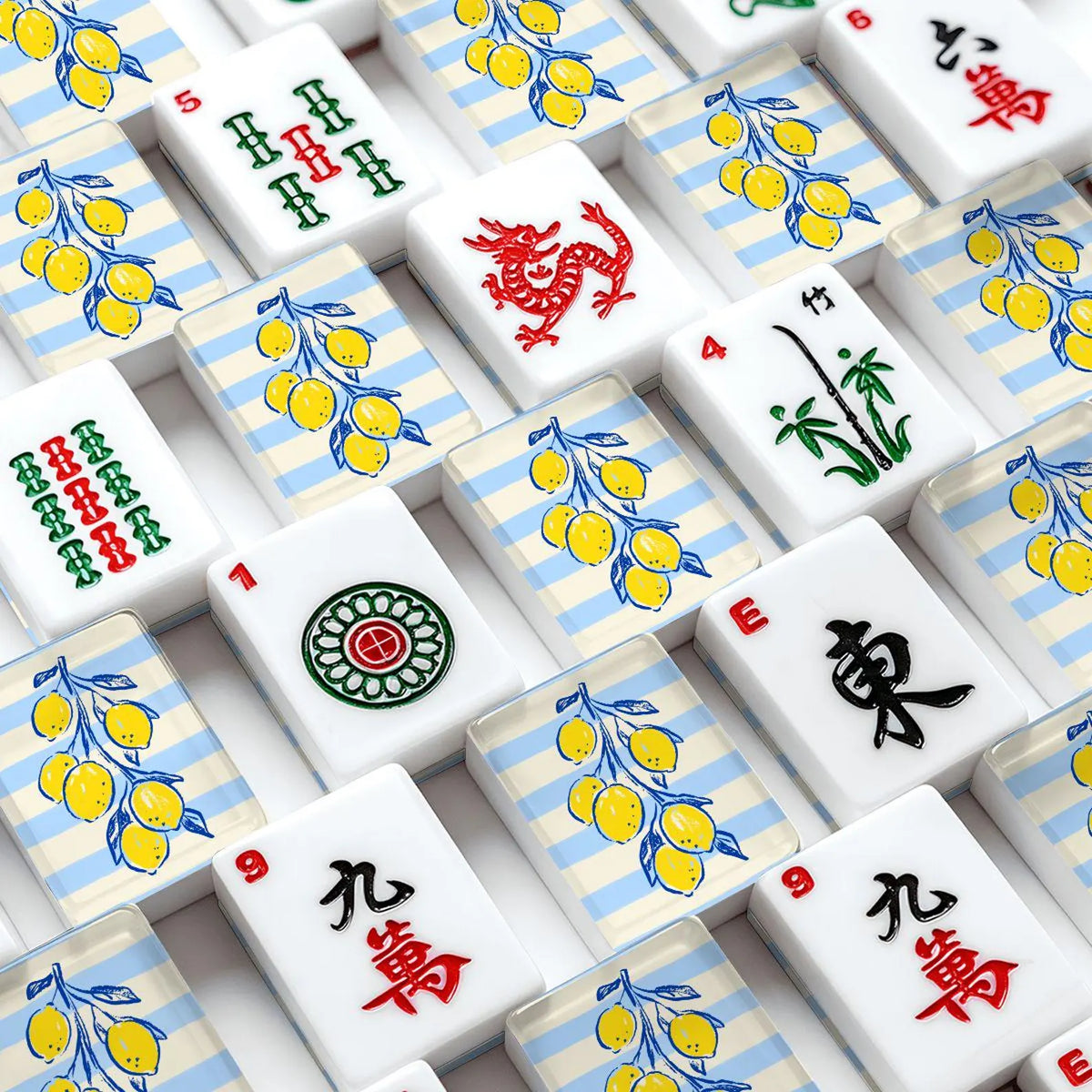 A close-up, top-down view of Mahjong tiles arranged in a grid featuring  yellow lemons on light blue striped backgrounds.